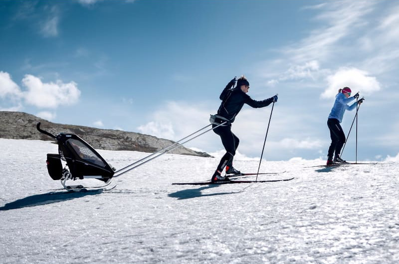 Åker skidor på fjället med Thule Chariot barnvagn på skidor