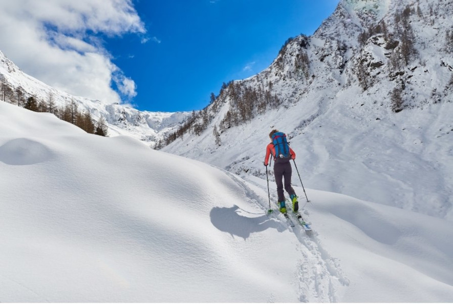 En skidåkare inom skimo på väg uppför fjällterräng